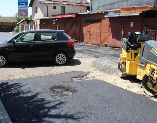 Muncitorii au asfaltat o strada in jurul unei masini