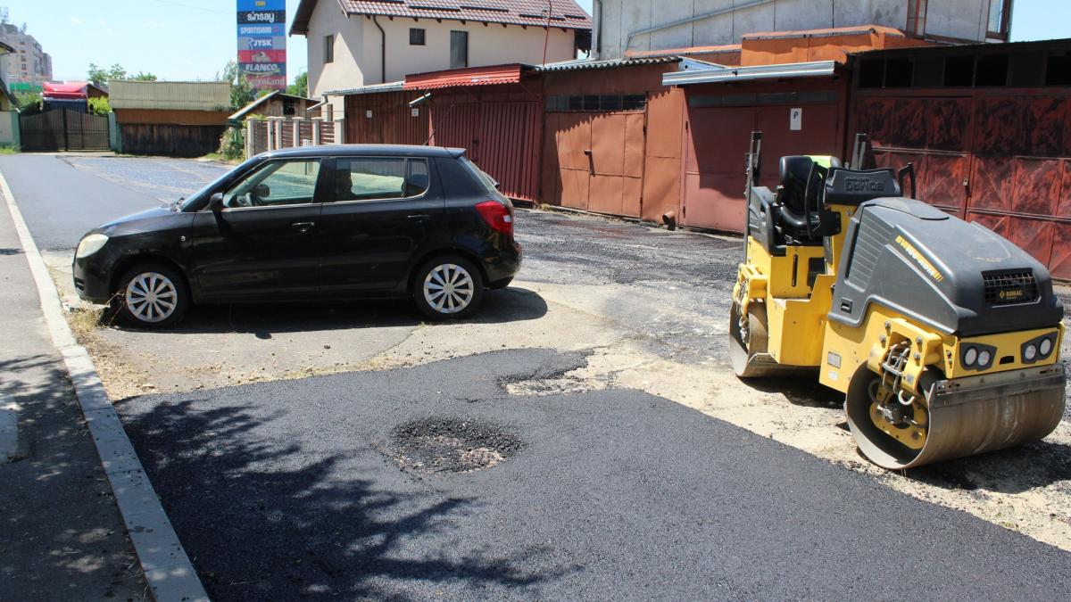 Muncitorii au asfaltat o strada in jurul unei masini